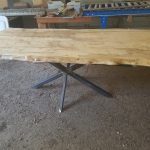 A table with metal legs and wooden top.